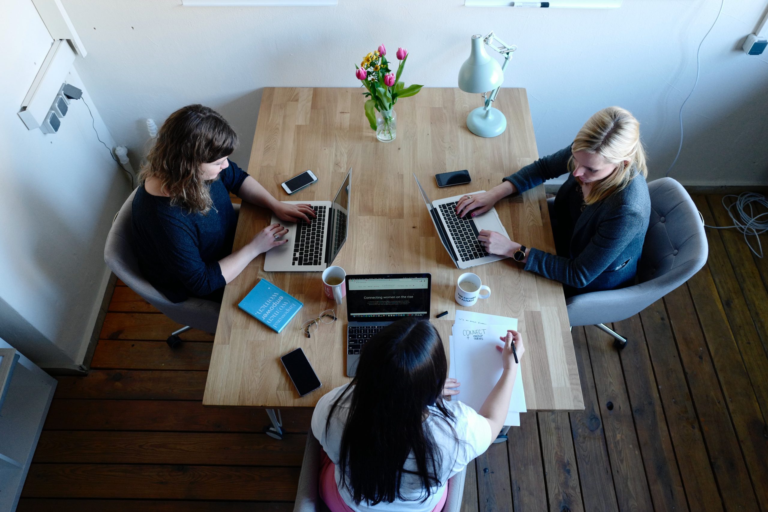 Image of three women working on laptops at a table for Version 1 SPSS Training